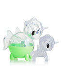 Two transparent unicorn figures: one, a green and round piece with wheels like something from the Unicorno Capsule Cuties Blind Box by Tokidoki; the other, a clear figure standing on four legs with a small horn, echoing the whimsical style of Tokidoki's creations.