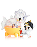 Two captivating unicorn-themed figurines from the Tokidoki Unicorno Capsule Cuties Blind Box stand side by side—one is orange and transparent, while the other is white with black and gold accents.