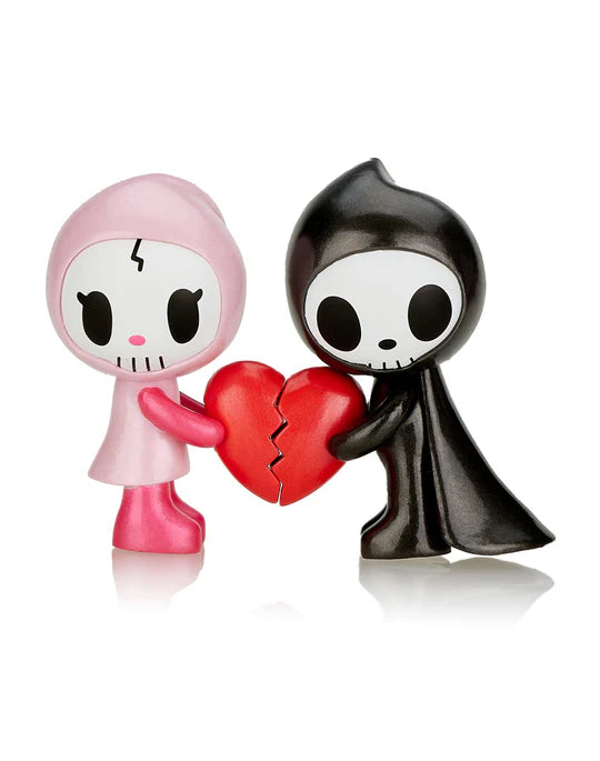 In the *Adios & Ciao Ciao Together Forever Special Edition* by *Tokidoki*, two cartoon figures—one pink and one black—hold parts of a broken heart together. These characters, featuring skull-like faces and simple features, perfectly embody 'Soulmates Forever' in this unique illustration.