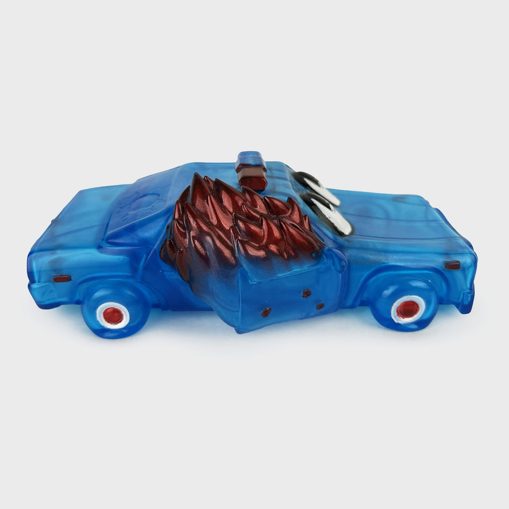 The ACABY — F*ck ICE Edition toy truck from DoomCo Designs stands strikingly against a plain white background with its blue color, red flames on the side door, and glossy finish resembling clear blue vinyl. Crafted in collaboration with Crocodile Jackson x DoomCo Designs.