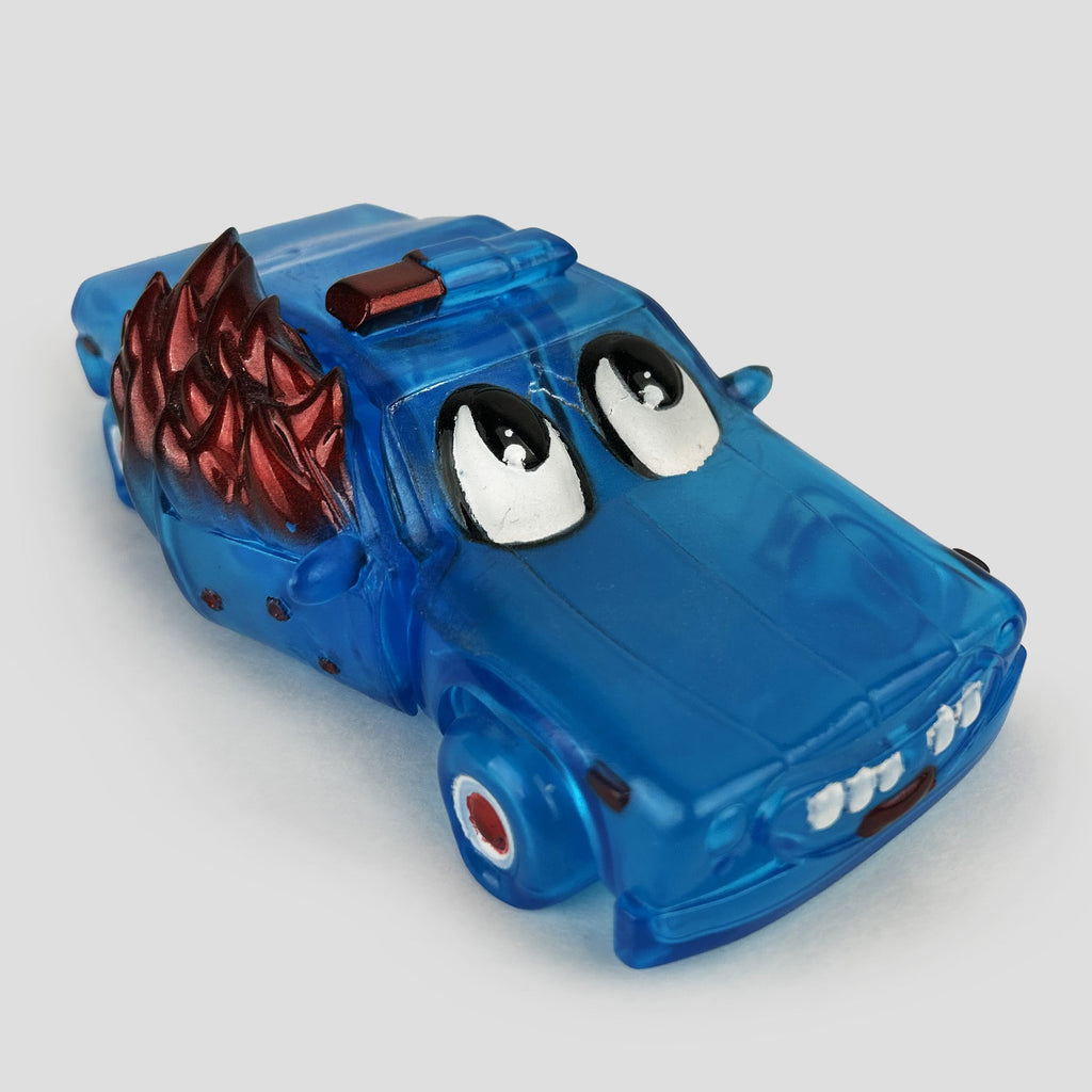 The Limited Edition ACABY — F*ck ICE by DoomCo Designs features a playful blue toy car with cartoon eyes and edgy red spikes on its sides, crafted in clear blue vinyl. This stunning collaboration piece is showcased against a plain background for maximum impact.