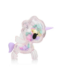 Introducing the Toki Mochi Donut Unicorno Sprinkle Star Special Edition by Tokidoki, a transparent unicorn toy featuring a lavender horn and tail, filled with vibrant star-shaped pieces inside.