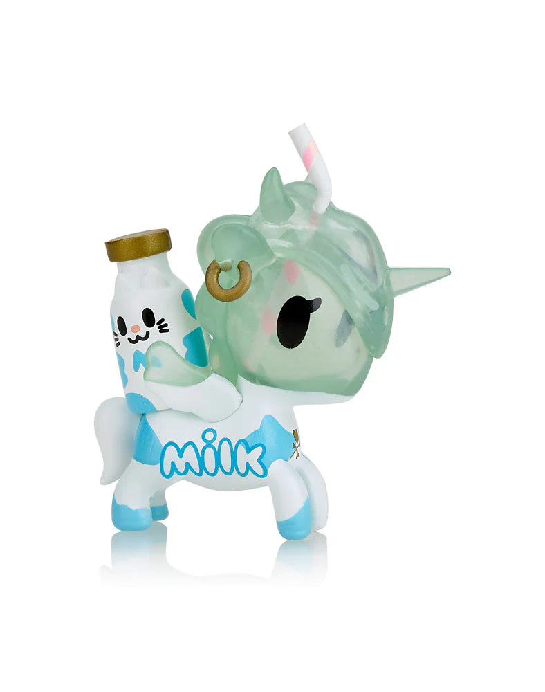 A Toki Mochi Donut Unicorno Blind Bag from Tokidoki reveals a whimsical figurine featuring a transparent green head, a blue and white body, and a charming milk bottle on its back, capturing the delightful surprises hidden in every Blind Box.