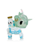 A Toki Mochi Donut Unicorno Blind Bag from Tokidoki reveals a whimsical figurine featuring a transparent green head, a blue and white body, and a charming milk bottle on its back, capturing the delightful surprises hidden in every Blind Box.