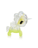 Observe the stunning unicorn-shaped figurine from Tokidoki's Toki Mochi Donut Unicorno Blind Bag collection, featuring a clear and green design with a yellow inner accent, a single horn, and large eye, elegantly posed on a reflective surface.