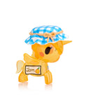 Unveil the magical Toki Mochi Donut Unicorno Blind Bag from Tokidoki, featuring a charming yellow unicorn figurine topped with a blue checkered hat and displaying a 