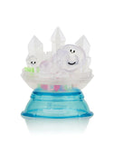 A small figurine of a smiling creature with clouds and crystal shapes, placed on a blue and transparent circular base with the word 