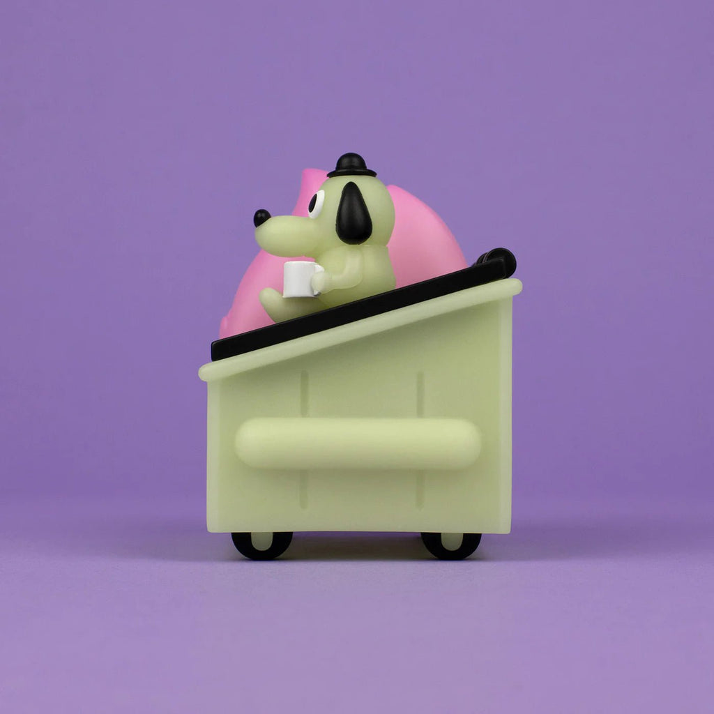 A toy dog, resembling the Dumpster Fire — This is Fine Glow Edition meme dog, sits in a pink box on a purple background.