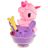 The tokidoki Shaved Ice Dreams Unicorno Honey Bunny Ice Special Edition features a pink unicorno figure perched on a purple bunny scoop of shaved ice in a glass dessert cup, finished with a red cherry and a yellow bear-shaped biscuit stick.