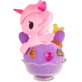 Introducing the tokidoki Shaved Ice Dreams Unicorno Honey Bunny Ice Special Edition: this special edition toy features a pink unicorn with a strawberry horn, perched on a purple, shaved ice-inspired base adorned with vibrant candy pieces, all beautifully displayed in a small clear bowl.