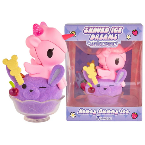 A special edition tokidoki Shaved Ice Dreams Unicorno Honey Bunny Ice figure features a pink unicorno nestled in a purple bunny-shaped shaved ice dessert with a cherry on top, accompanied by its matching box labeled “Shaved Ice Dreams Unicorno Honey Bunny Ice.” This charming collectible adds a magical tokidoki touch to any sweet collection.