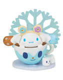 In the tokidoki x Hello Kitty and Friends Winter Dreams Blind Box, a charming character adorned with donut earmuffs is nestled in a blue cup, accompanied by marshmallow figures against a snowflake backdrop, capturing Tokidoki's fanciful style.