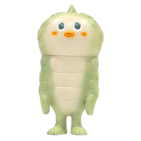 A green, chubby, cartoon-like creature with orange cheeks, a beak-like mouth, and small limbs stands facing forward. The creature is Lily — Original from How2Work (HK).