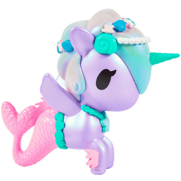 The Magical Tides Mermicorno Tokidoki by tokidoki is a pastel-colored toy figure featuring a unique blend of unicorn and mermaid, complete with a blue horn, purple body, pink mermaid tail, wings, and adorned with decorative beads and shells on its head—radiating ocean-inspired charm that’s perfect for underwater adventures.