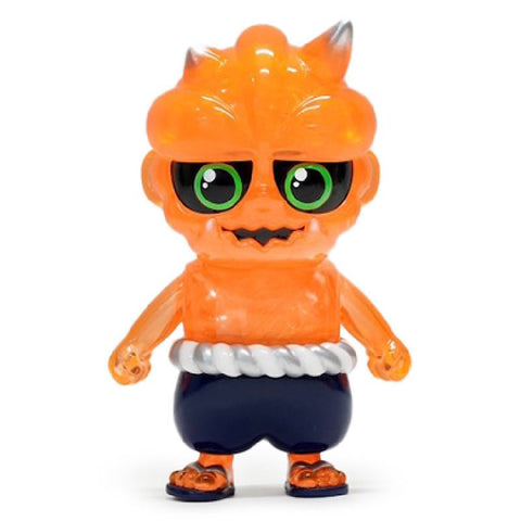 A small, orange toy figure with large green eyes, horns, and a mischievous expression, wearing dark blue shorts and a white rope belt from How2Work (HK), named Oniki — Ghost.