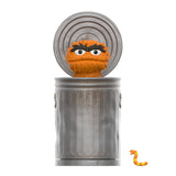 A furry orange character peeks from a metallic trash can with an open lid, while a small, orange-striped worm is near the can's bottom—a perfect scene for any Sesame Street Series 1 Super 7 Blind Box enthusiast.