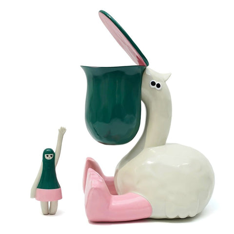 A whimsical ceramic figure resembling a bird with a green head and an open beak, Paku the Bird — Original by The Little Hut (HK), sits next to a smaller human-like figure with a green and pink outfit, waving its hand.
