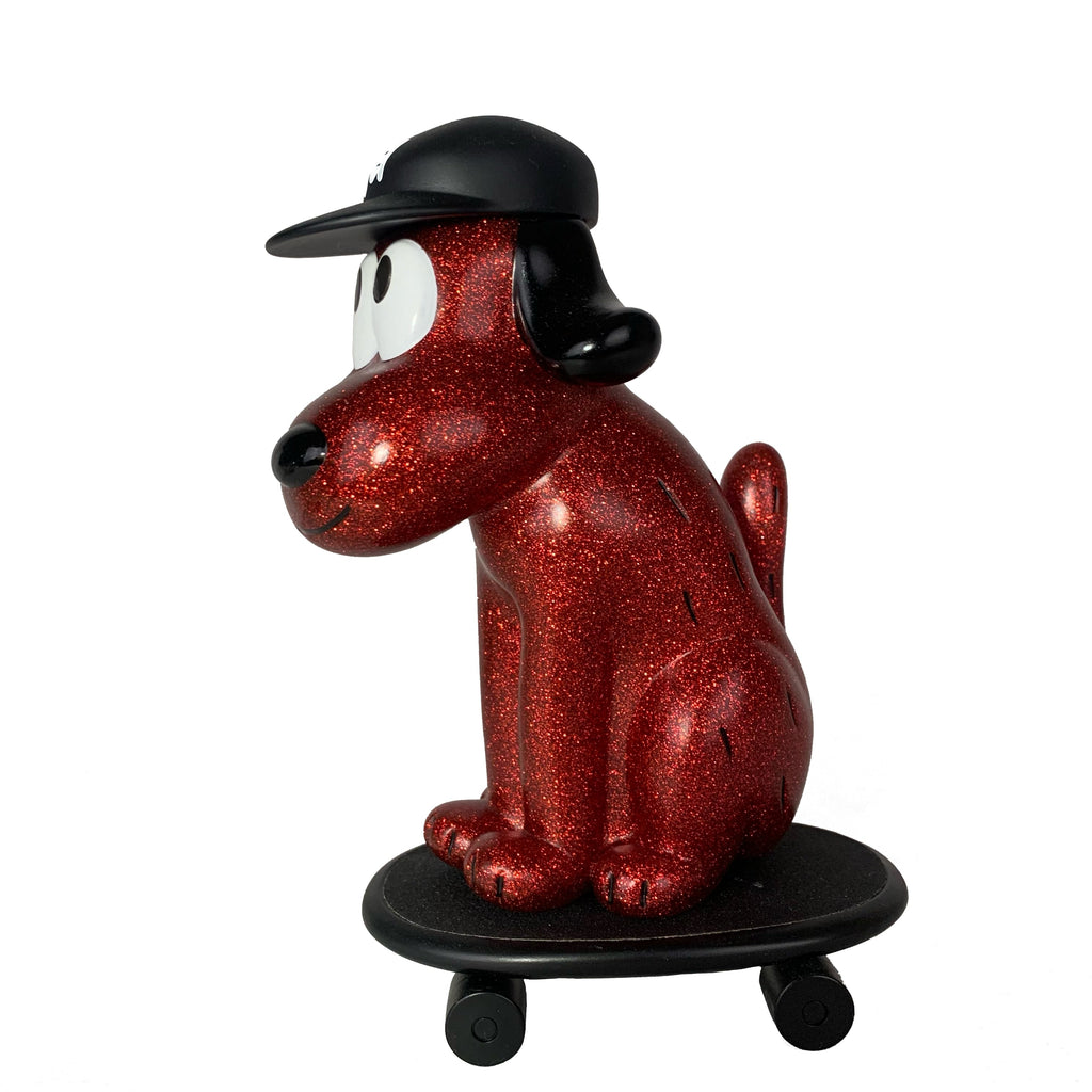 The How 2 Work One-Chu Sk8 - Red Glitter is an eye-catching 8-inch collectible cartoon dog figure with a black cap, sitting on a black skateboard, featuring glittery red detail.