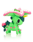 A green toy from the After Dark Unicorno Series 4 - Blind Box with a pink hat on it by tokidoki.