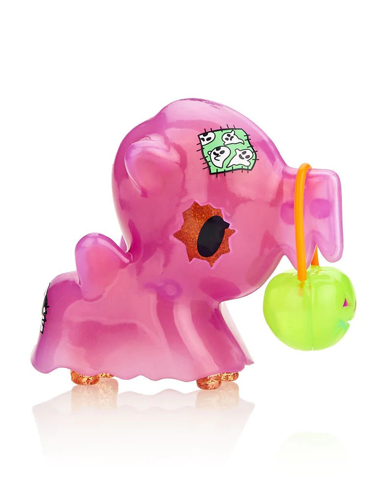 A pink stuffed animal from the tokidoki After Dark unicorno Series 4 - Blind Box with a green apple in its mouth.