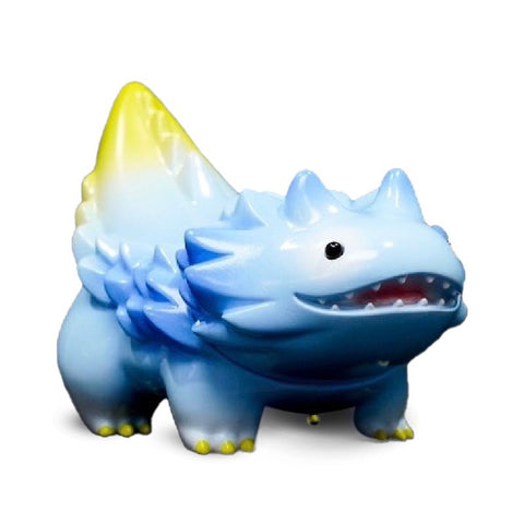 A Seedlas Brother — Sky, a small, blue, dragon-like toy with a yellow-tipped tail and tiny horns, featuring a textured back and an open-mouthed expression from Paradise Toy (TW), is standing upright against a white background.