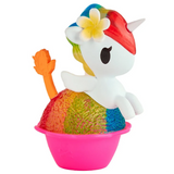 A vibrant unicorn figure featuring a red mane, yellow tail, white wings, and a flower tucked behind its ear sits inside a pink cup with a rainbow-textured base. Part of the Shaved Ice Dreams Unicorno Blind Box series by tokidoki, this charming collectible is the perfect addition to any blind box collection.