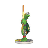A side view of the Kidrobot (US) Teenage Mutant Ninja Turtles TMNT GURU Resin Figure by CHOGRIN shows it holding a staff on a round base with detailed belt items—a must-have collectible for TMNT fans.