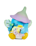 A blue penguin figurine with yellow feet and a white belly, wearing a green and purple hat, holds a unicorn toy and flower. Inspired by Tokidoki x Hello Kitty and Friends Butterfly Garden Blind Box by Rotofugi. White background.