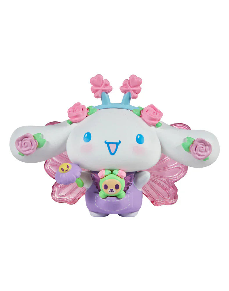 The Rotofugi Tokidoki x Hello Kitty and Friends Butterfly Garden - Cinnamoroll & Rosie Special Edition is a cute collectible featuring Cinnamoroll in a purple outfit with pink wings, a flower crown, and holding a bear-shaped accessory.