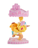 A small yellow unicorn figurine with a pink mane and pearl necklace holds a yellow bear under a heart-canopy on a pink base—perfect for fans of the tokidoki x Hello Kitty and Friends Sweet Pink Carousel Blind Box by tokidoki.