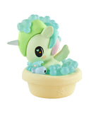 A tokidoki Baby Unicorno Blind Box figurine features green and blue accents, sitting in a beige tub with blue bubbles and holding a blue fish—a cute collectible from the tokidoki brand.