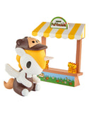 The tokidoki Farmers Market Unicorno Blind Box includes a cute collectible figurine with a brown hat and apron, sitting by a yellow-striped market stall—an adorable treat for any tokidoki fan.