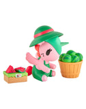 A cute tokidoki Farmers Market Unicorno Blind Box figurine in green overalls and a hat sits beside watermelons, embodying the playful collectible style of the tokidoki brand.