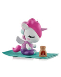 A Spa Day Unicorno from the Tokidoki Spa Day Unicorno Blind Box sits cross-legged on a teal mat with wings and a brown oven, bringing kawaii wellness vibes to your collection.