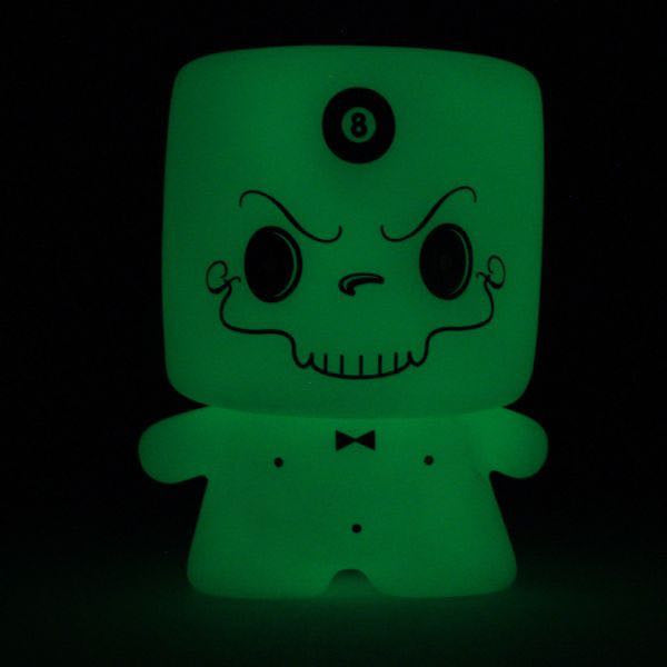 Introducing Grim Marshall by 64 Colors, a limited edition glow-in-the-dark figurine from Squibbles Ink + Rotofugi (US). Featuring an angry skull face with a bowtie and the number 8 emblazoned on its forehead, its glowing appearance adds an eerie touch that makes it stand out in any collection.