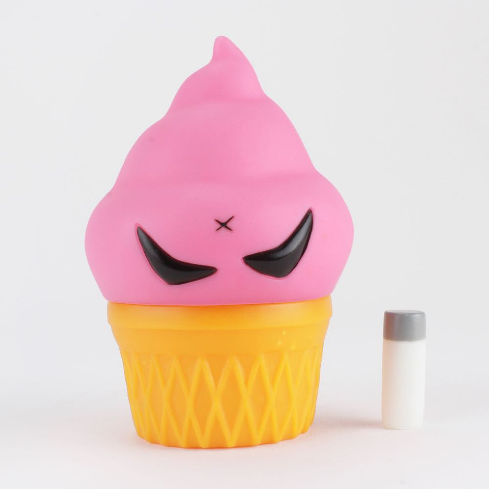 The Smorkin' Monger Jerome - Strawberry by Squibbles Ink + Rotofugi (US) is a toy ice cream cone with a pink top, yellow base, and angry eyes. A small cylinder object is next to Jerome on the pristine white background.