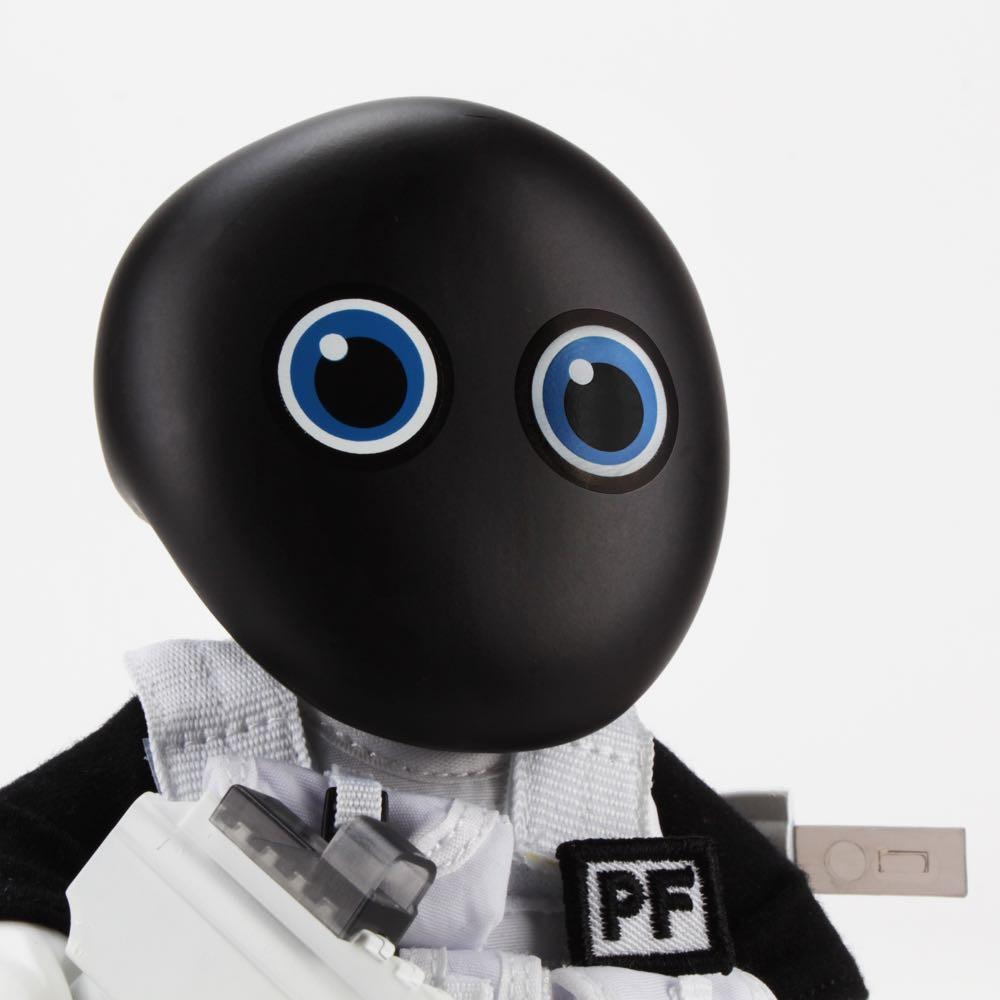 A close-up of the Squadt NOZZEL S005 [PEACE F***ER] by Playge (HK/US): a robot with a black oval head, large blue eyes, and a white/black outfit labeled 