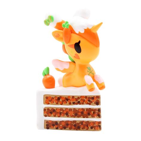 A dessert-themed Delicious Unicorno Blind Box figurine of an orange unicorn sitting on top of a cake from tokidoki.