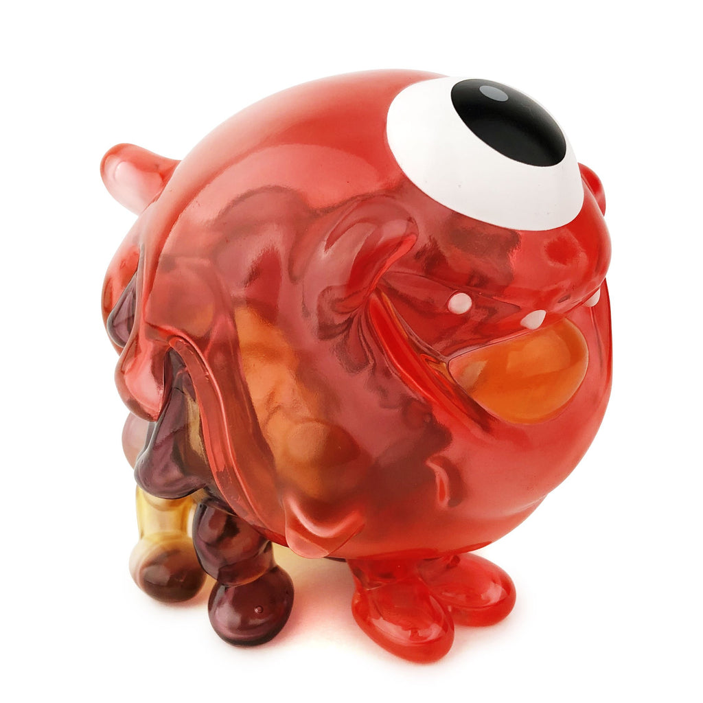 A red glass Gellog — Type-C from Strangecat Toys (US) with an eye on it.