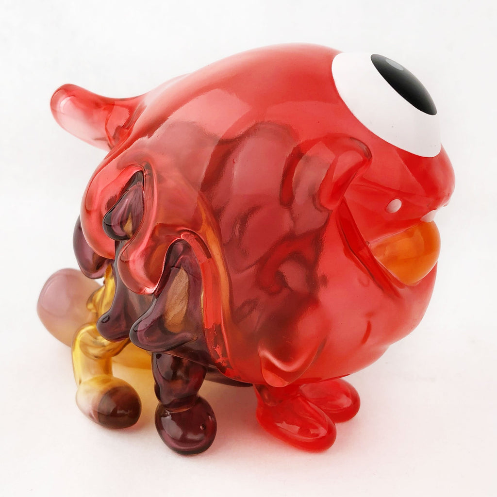 A red glass Gellog — Type-C with a yellow eye from Strangecat Toys (US).