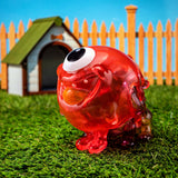 A red Gellog — Type-C with a dog house in the grass created by Strangecat Toys (US).