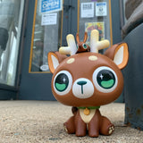 The littlest DeerCat & Friends reindeer is snoozing in front of a store from Strangecat Toys (US).