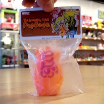 A person is holding a Popsoda Finger Puppet - Orange in a bag.