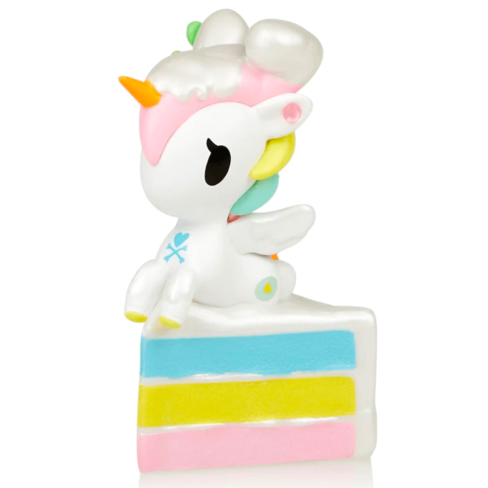 A white 14 Karrots Unicorno figurine on a piece of cake, inspired by tokidoki.