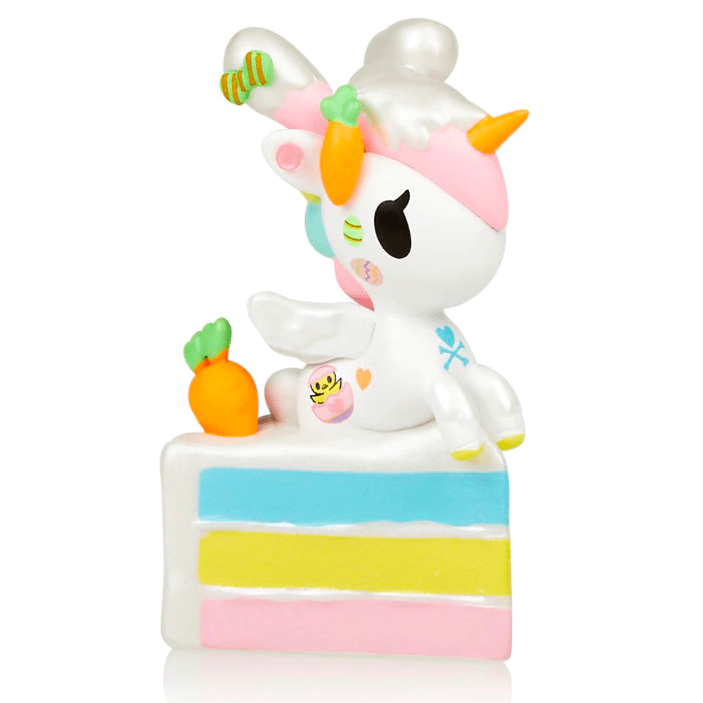A 14 Karrots Unicorno figurine sitting on top of a cake.
