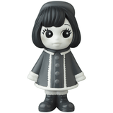 A black and white figurine of a girl wearing a coat, inspired by Japanese vinyl toy artists, the VAG 31 — Uramy and Tsurami by Medicom (JP).