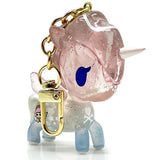 A pink Celeste Unicorno keychain with a gold chain, perfect as a bag charm by tokidoki.