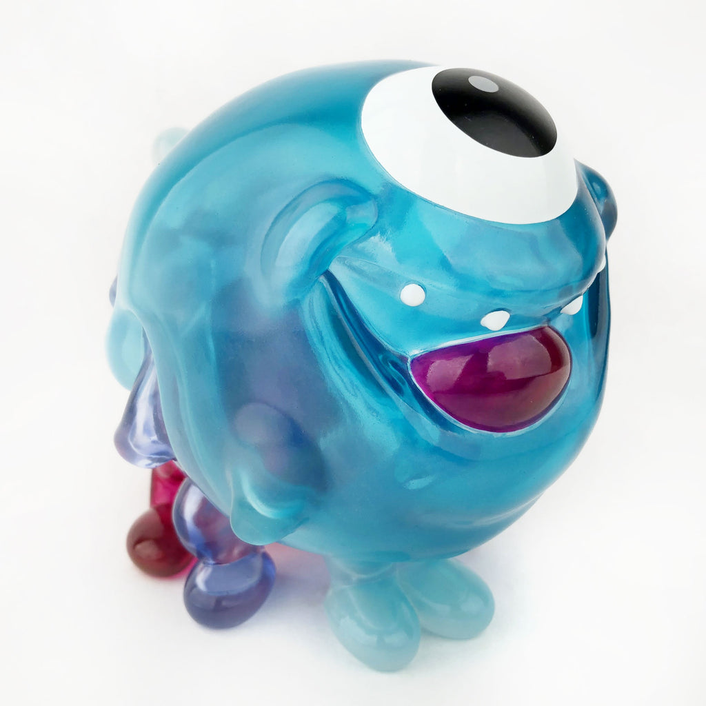A Gellog — Type-D (Rotofugi Exclusive) is lounging on a white surface, created by Strangecat Toys.