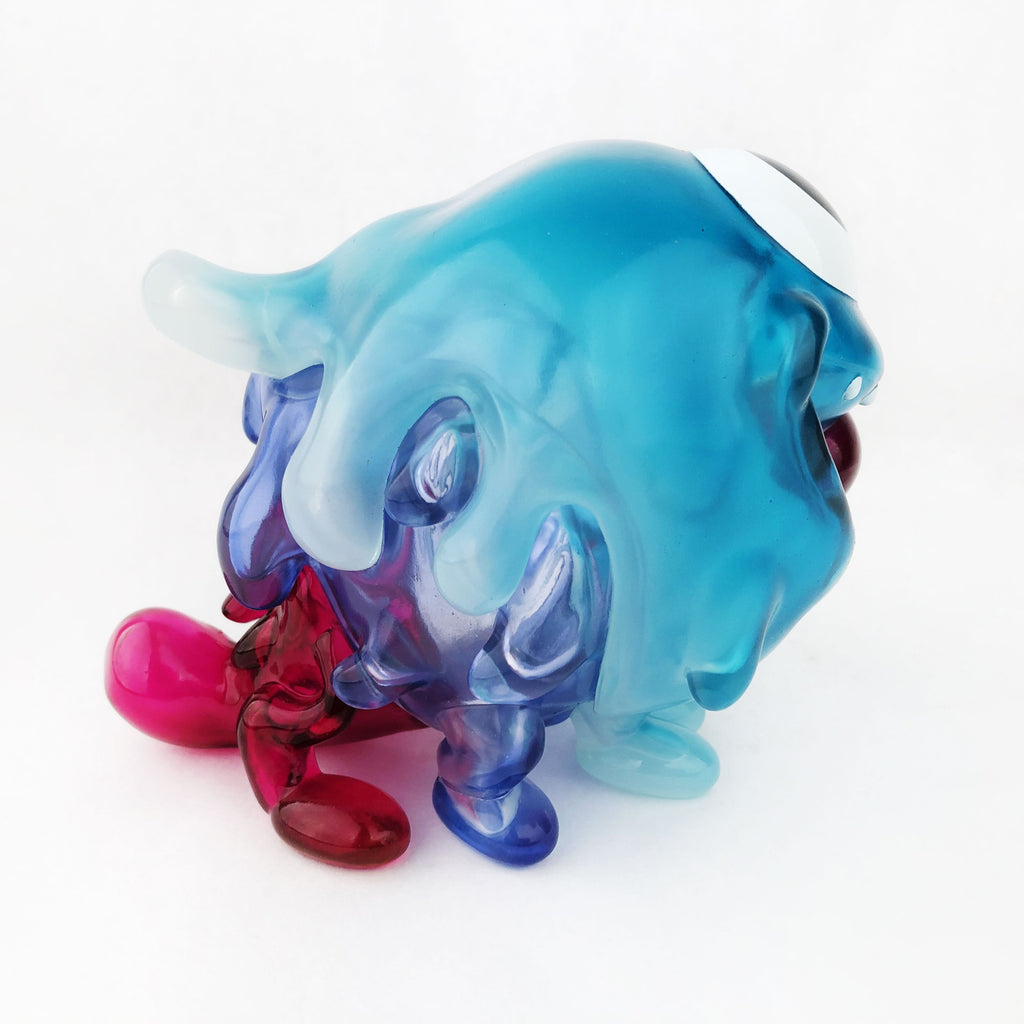 A Gellog — Type-D (Rotofugi Exclusive) beast sculpture in blue, pink, and purple hues is perched on a white surface.