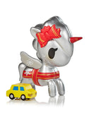 A silver Unicorno Holiday Series 4 Blind Box toy next to a yellow car from tokidoki.